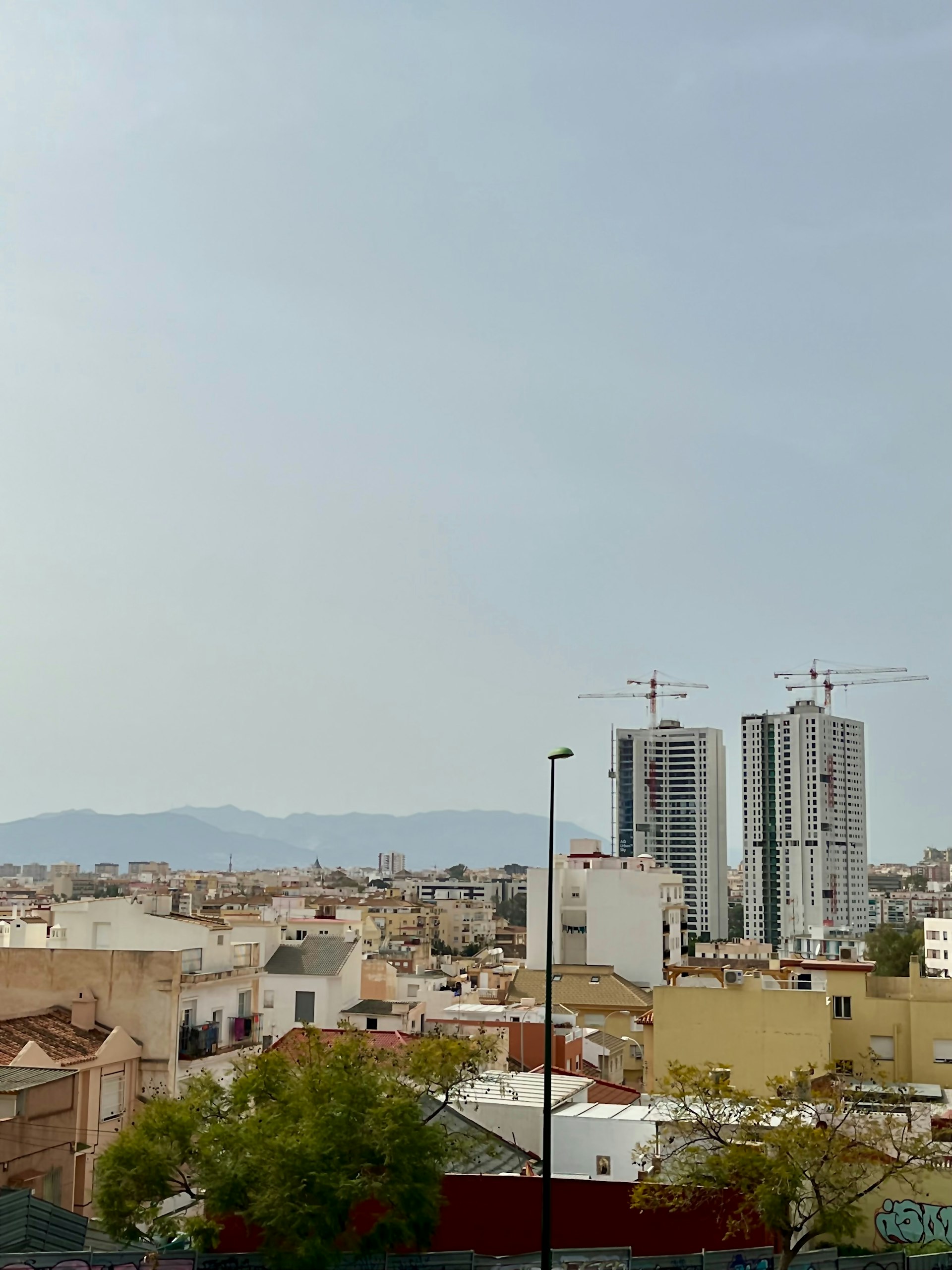 Construction cranes over commercial buildings rising on a skyline