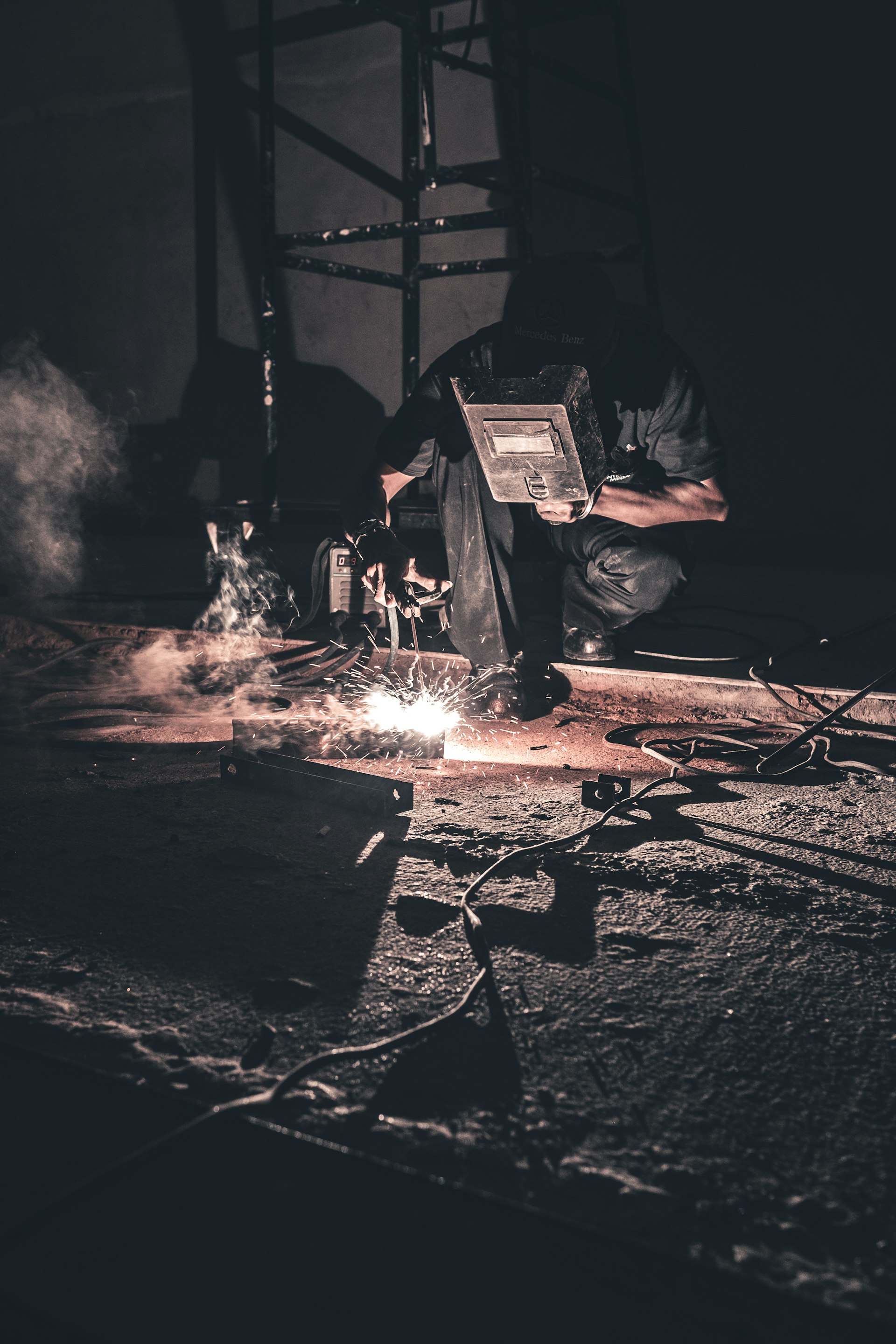 Welder fabricating steel members for a building structure